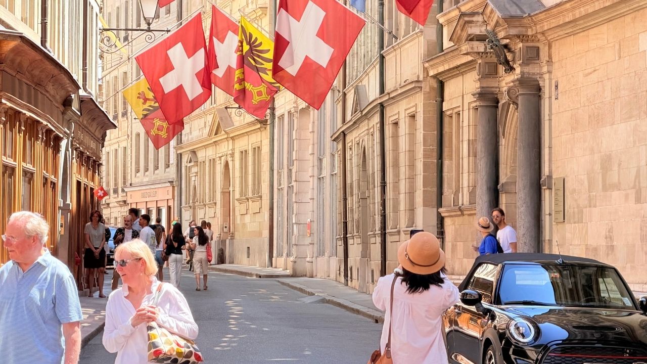 A Geneva street beneath Swiss flags, featured image for The AI Earth Manifesto