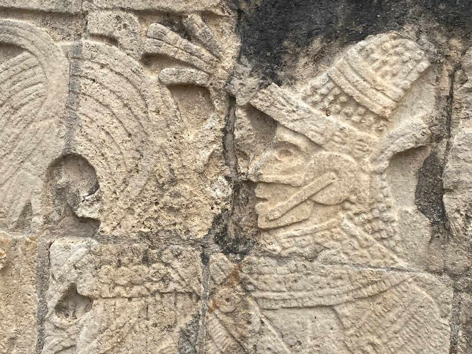 An ancient carved stone face, worked by hand and weathered by time